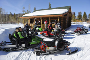 A group of snowmobilers taking a break from their sleds