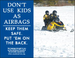 Horizontal Poster of Snowmobilers and text ‘Don't Use Kids as Airbags. Keep Them Safe-Put Them on the Back'